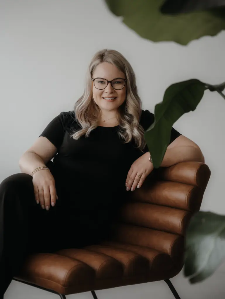 Berthilde Bittner, Gründerin von Beblick aus Niederbayern, sitzt lächelnd in einem lichtdurchfluteten Raum auf einem modernen Stuhl neben einer Pflanze – Unternehmer Coaching Schierling für Führungskräfte, Geschäftsführer und Gründer.